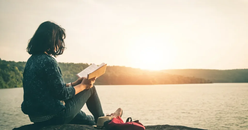 穏やかな湖畔で読書を楽しむ人、安定を象徴